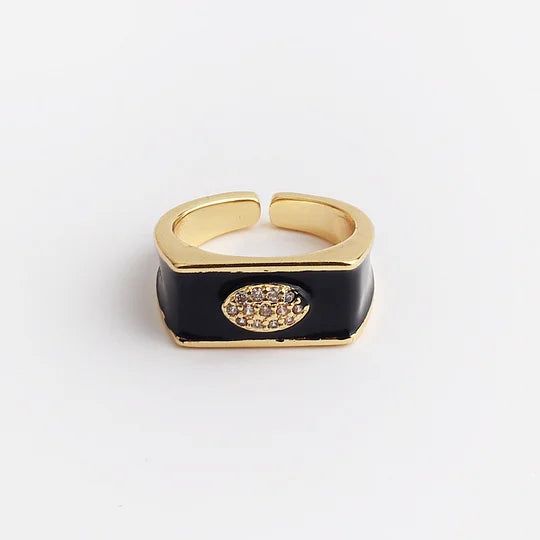 Gold and black ring with a decorative element on a light gray background