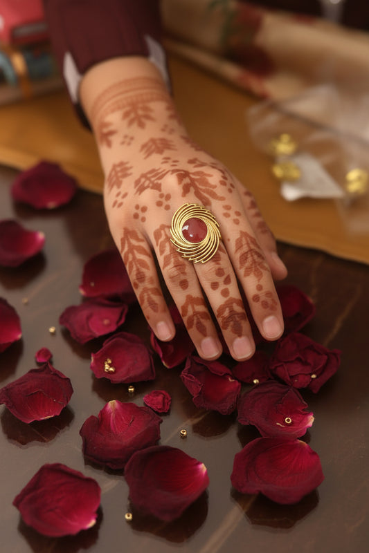 Gold plated ring featuring a red stone,