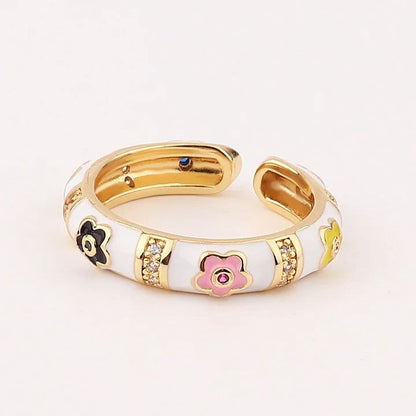Gold and white ring with floral designs on a light background