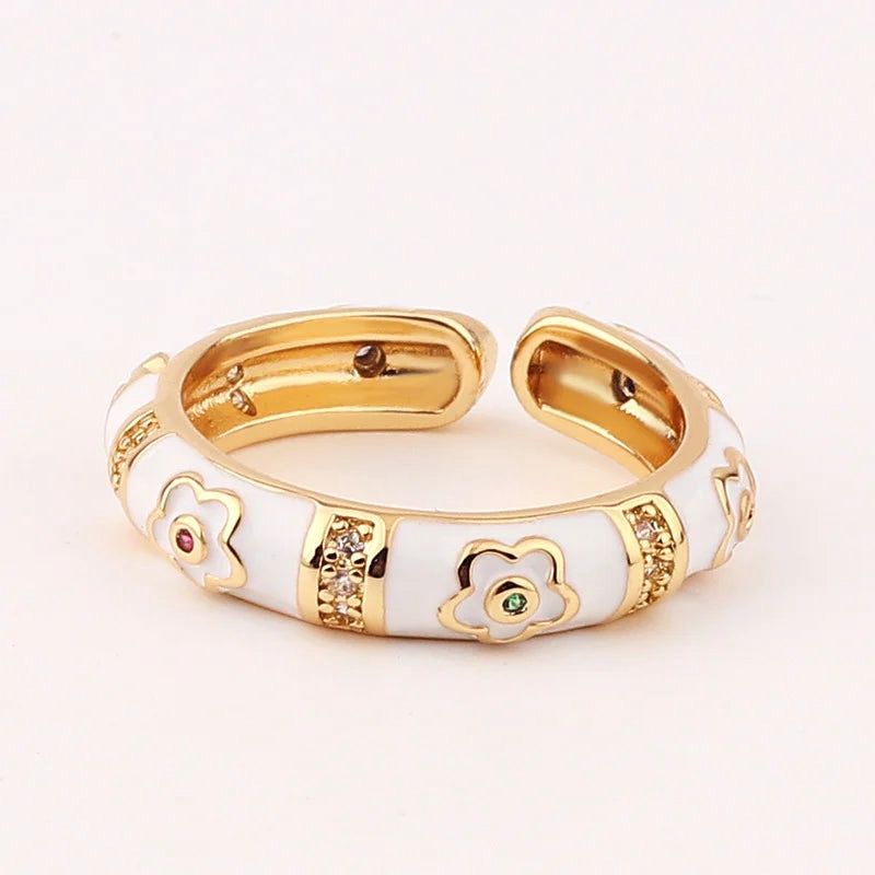 Gold and white bracelet with floral designs on a light background