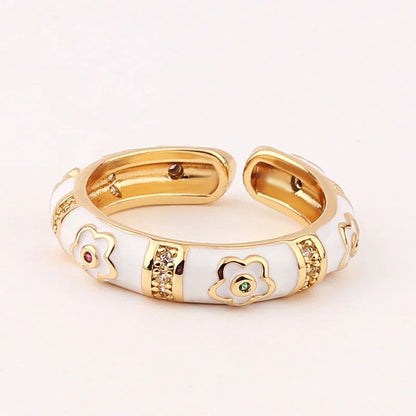 Gold and white bracelet with floral designs on a light background