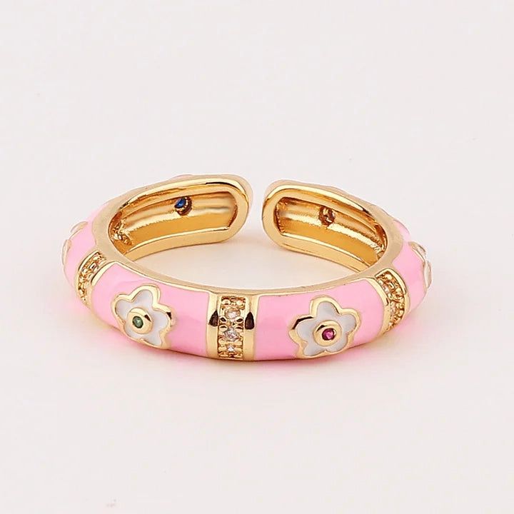 Pink and gold ring with floral designs on a light pink background