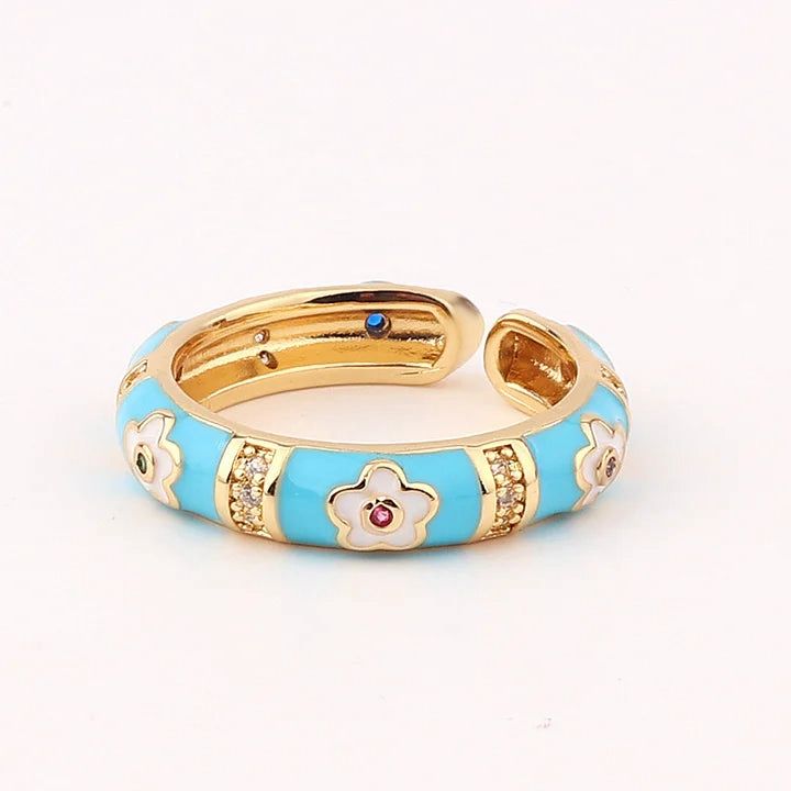 Gold and blue ring with floral designs on a white background