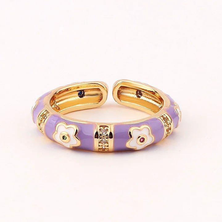 Gold and purple bracelet with floral designs on a white background