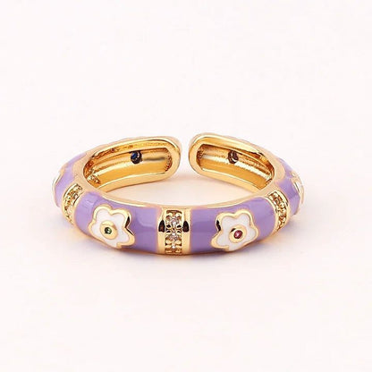Gold and purple bracelet with floral designs on a white background